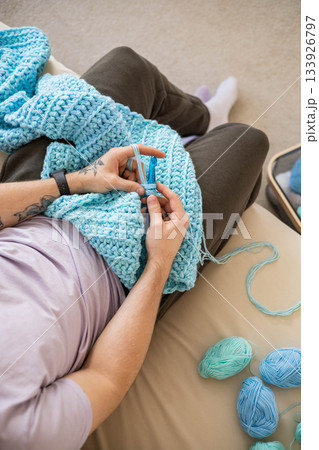 Modern hipster man crochet handmade hobby use hook knitting needles and wool yarn top view closeup Modern hipster man crochet handmade hobby use hook knitting needles and wool yarn top view closeup 133926797