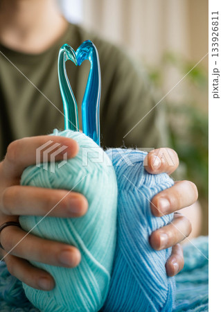 Crochet hooks folded in the shape of a heart and a skein of yarn. Crochet hooks folded in the shape of a heart and a skein of yarn. 133926811