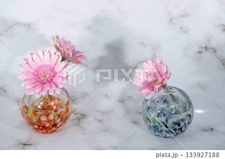 ガラスの一輪挿しに挿した二組の桃色のガーベラの花 133927188