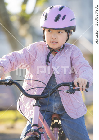 アジア人の子どもが公園で自転車練習に取り組む穏やかな外遊び 133927831