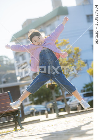 公園で高くジャンプする女の子の元気あふれる屋外シーン 133927834