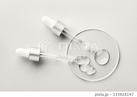 Two droppers applying clear hyaluronic acid gel. Color of the Year concept Two droppers applying clear hyaluronic acid gel. Color of the Year concept 133928147
