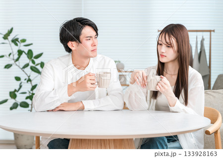 自宅のリビングでダイニングテーブルに座る若いアジア人夫婦(将来設計,ライフプラン,悩む,考える) 自宅のリビングでダイニングテーブルに座る若いアジア人夫婦(将来設計,ライフプラン,悩む,考える) 133928163