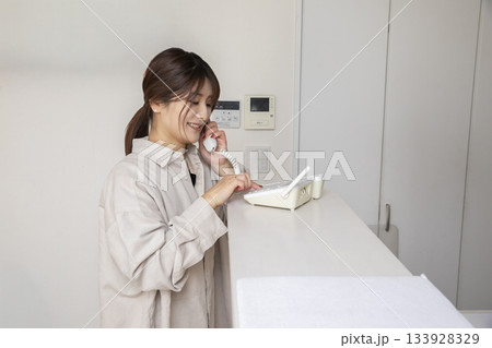 固定電話に出る女性 固定電話に出る女性 133928329