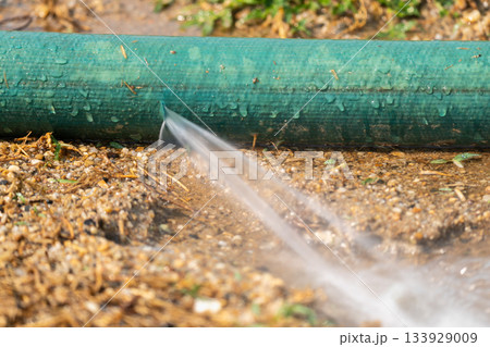 Water leaking from hole in a industrial hose. Water leaking from hole in a industrial hose. 133929009