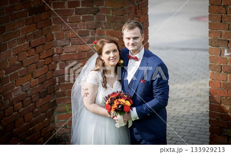 Happy Wedding Couple Embracing by Brick Archway Happy Wedding Couple Embracing by Brick Archway 133929213