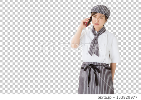 A woman wearing a chef's coat with a troubled expression talking on a smartphone 133929977