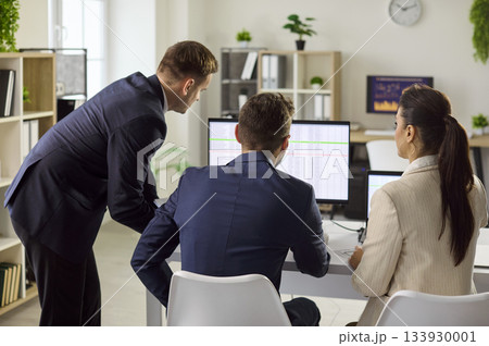 Business team reviewing spreadsheets on monitors during office workflow planning Business team reviewing spreadsheets on monitors during office workflow planning 133930001