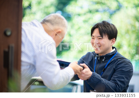 宅食弁当を渡す配達員 133931155