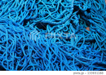 A blue stringy material with many knots A blue stringy material with many knots 133931160