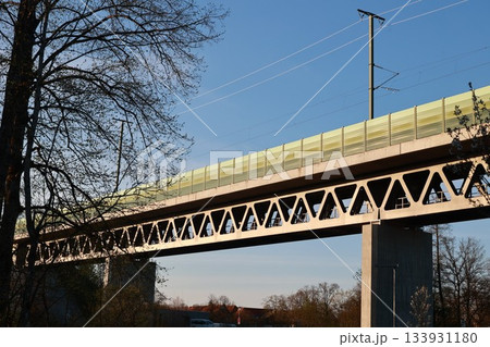 A bridge with a green railing and a tree in the background A bridge with a green railing and a tree in the background 133931180