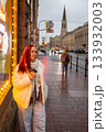 A happy woman drinks coffee in the evening on a neon lit street. date with lover 133932003