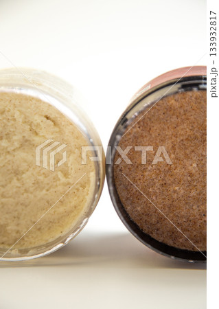 Jars of body scrub display contrasting textures, one creamy and one coarse, emphasizing natural ingredients and a soothing atmosphere for skincare lovers Jars of body scrub display contrasting textures, one creamy and one coarse, emphasizing natural ingredients and a soothing atmosphere for skincare lovers 133932817