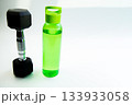 Dumbbell and water bottle are arranged on a white background, representing a healthy lifestyle, fitness motivation, and hydration for active routines 133933058