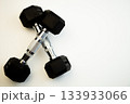 Crossed black hex dumbbells on a pristine white background, highlighting fitness equipment for strength training, perfect for gym enthusiasts and health-conscious individuals seeking motivation 133933066
