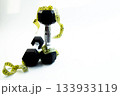Black dumbbells are artistically arranged with yellow measuring tape on a bright white background, representing fitness, health, and wellness concepts for active lifestyles 133933119
