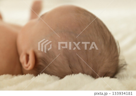 Baby lies quietly on a soft surface enjoying a calm moment Baby lies quietly on a soft surface enjoying a calm moment 133934181