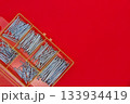 赤い背景に置かれた釘セット 133934419