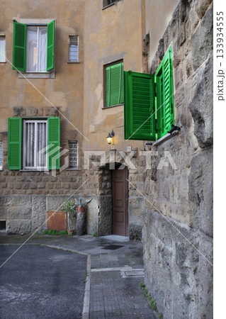 charming italian village alley with green shutters and stone walls 133934555