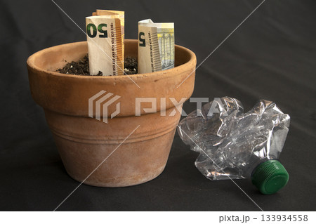 cash growing in soil with plastic waste symbolizing green finance cash growing in soil with plastic waste symbolizing green finance 133934558