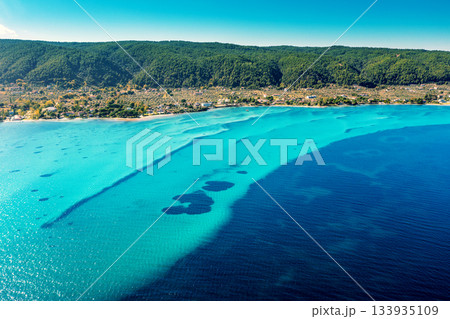 Seascape on a sunny day. Top view of a beautiful bay. Seabed texture in Vourvourou, Greece Seascape on a sunny day. Top view of a beautiful bay. Seabed texture in Vourvourou, Greece 133935109
