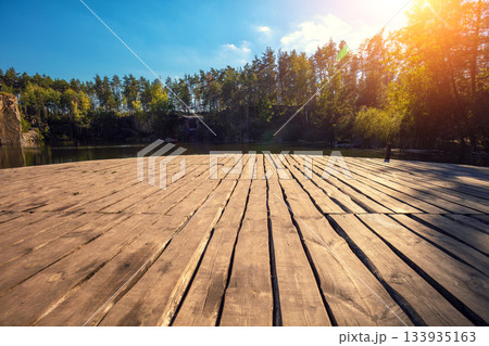 Serene lake with a wooden round pier. Nature landscape Serene lake with a wooden round pier. Nature landscape 133935163