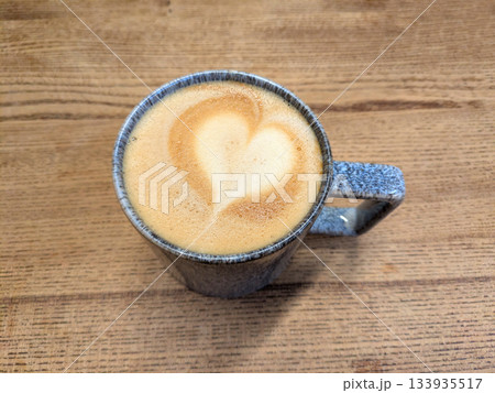 Close Up of an Oat Milk Latte Coffee in White Cup on a Rustic Wooden Table Background with Love Heart Close Up of an Oat Milk Latte Coffee in White Cup on a Rustic Wooden Table Background with Love Heart 133935517