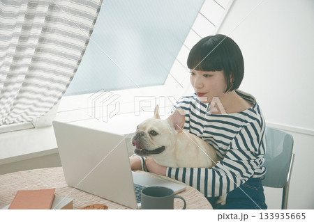 PC作業をする女性と犬 133935665
