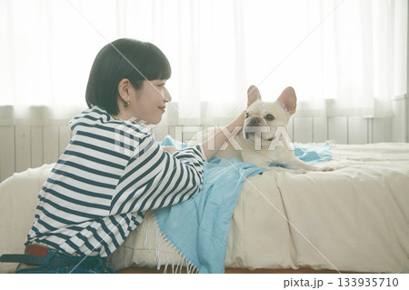 寝室でくつろぐ犬と女性 寝室でくつろぐ犬と女性 133935710