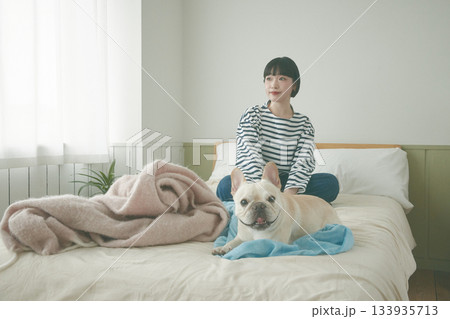 ベッドの上でくつろぐ犬と女性 ベッドの上でくつろぐ犬と女性 133935713