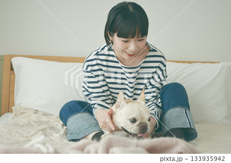 ベッドでくつろぐ犬と女性 ベッドでくつろぐ犬と女性 133935942