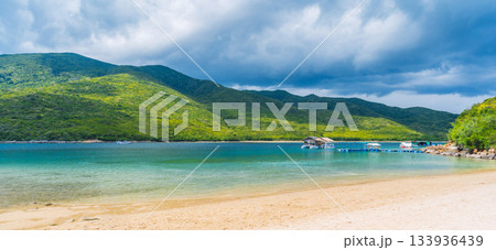 sandy beach on tropical island in a bay by sea on summer. Luxury exotic resort in Asia. Landscape panorama with a view of coast by the ocean 133936439