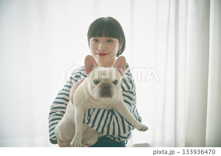 窓辺で犬を抱き抱える女性 133936470