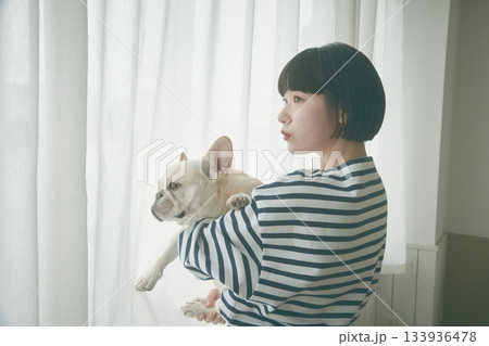 窓辺で犬を抱き抱える女性 窓辺で犬を抱き抱える女性 133936478
