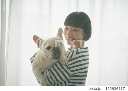 窓辺で犬を抱き抱える女性 窓辺で犬を抱き抱える女性 133936517