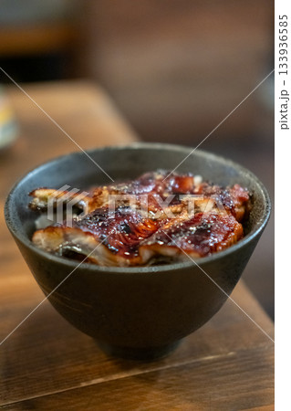Unagi don. Grilled eel with sweet sauce rice bowl on wooden table. Unagi don. Grilled eel with sweet sauce rice bowl on wooden table. 133936585