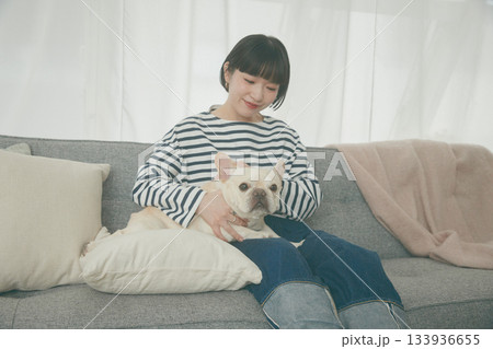 ソファでくつろぐ犬と女性 133936655