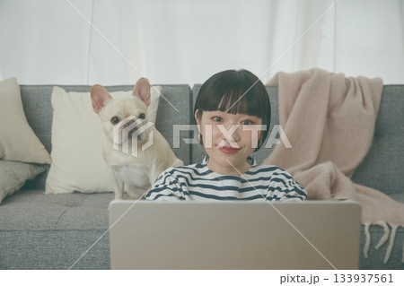 パソコン作業をする女性と見守る犬 パソコン作業をする女性と見守る犬 133937561