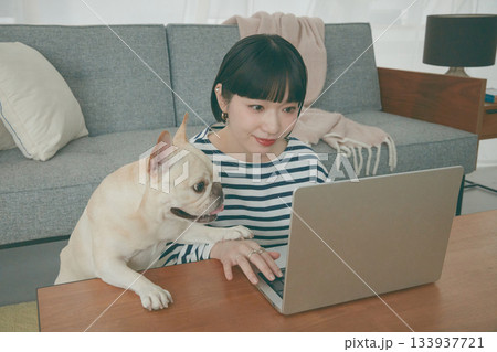 パソコン作業をする女性と見守る犬 133937721