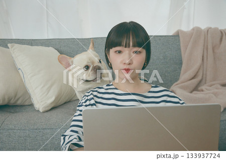 パソコン作業をする女性と見守る犬 パソコン作業をする女性と見守る犬 133937724
