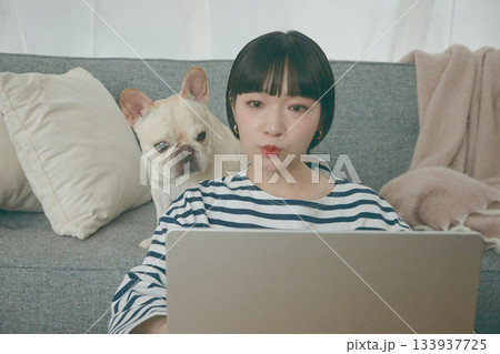 パソコン作業をする女性と見守る犬 133937725