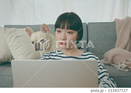 パソコン作業をする女性と見守る犬 パソコン作業をする女性と見守る犬 133937727
