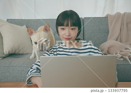 パソコン作業をする女性と見守る犬 パソコン作業をする女性と見守る犬 133937795