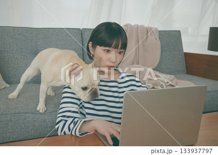 パソコン作業をする女性と見守る犬 パソコン作業をする女性と見守る犬 133937797