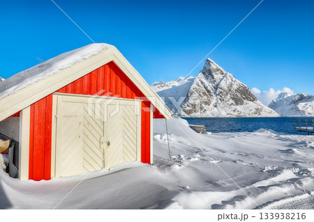 Traditional Norwegian houses on the shore of Reinefjorden on Toppoya island and snowy mountaines in background Traditional Norwegian houses on the shore of Reinefjorden on Toppoya island and snowy mountaines in background 133938216