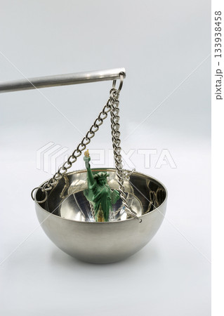 Statue of Liberty figurine on metal balance scale closeup. Statue of Liberty figurine on metal balance scale closeup. 133938458