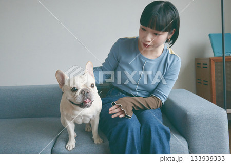 ソファでくつろぐ犬と若い女性 ソファでくつろぐ犬と若い女性 133939333
