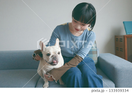 ソファでくつろぐ犬と若い女性 ソファでくつろぐ犬と若い女性 133939334