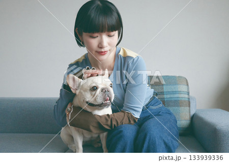 ソファでくつろぐ犬と若い女性 ソファでくつろぐ犬と若い女性 133939336