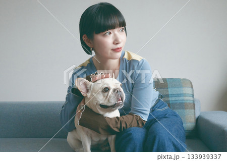 ソファでくつろぐ犬と若い女性 133939337